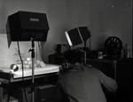 Employee sets up a still-life under studio lights by WBAY-TV